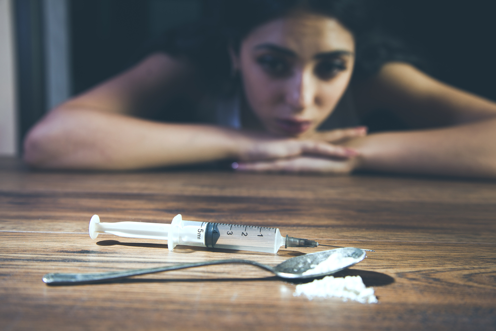 woman looking at drugs thinking about lapse vs relapse