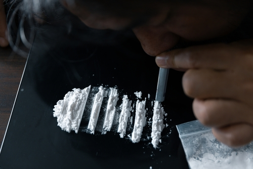 person snorting cocaine lines on table