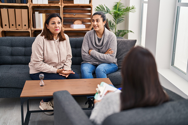 A mother and daughter participate in communication activities in family therapy.