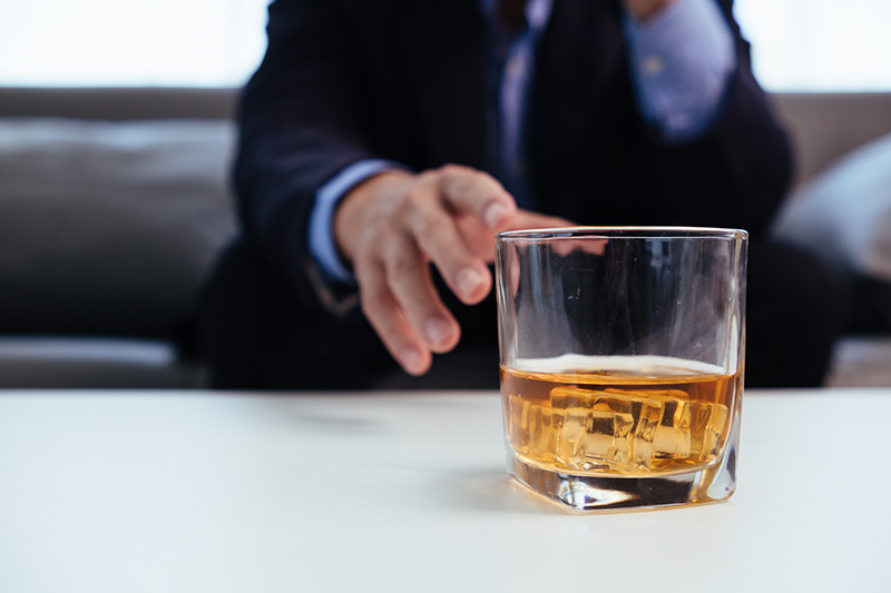 A person drinks an alcoholic beverage.