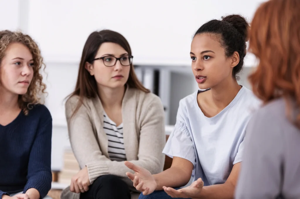 People participate in group therapy at a drug rehab center.