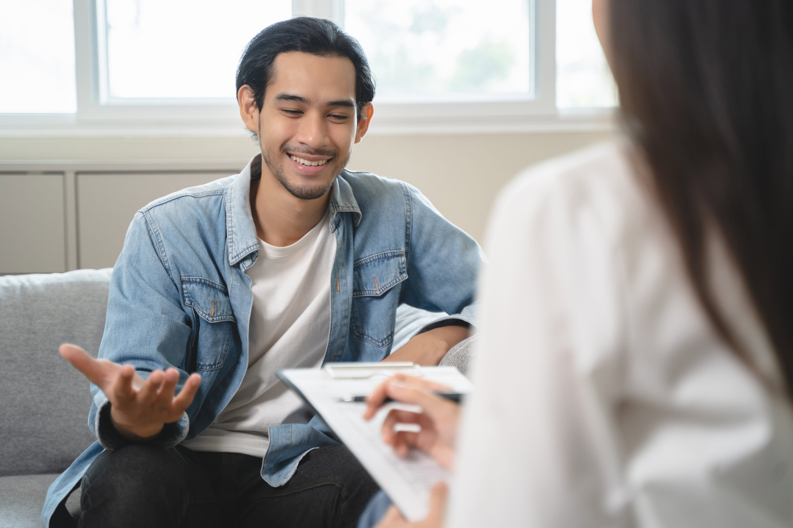 Asian man talking to a woman at an opiate rehab center in Massachusetts.