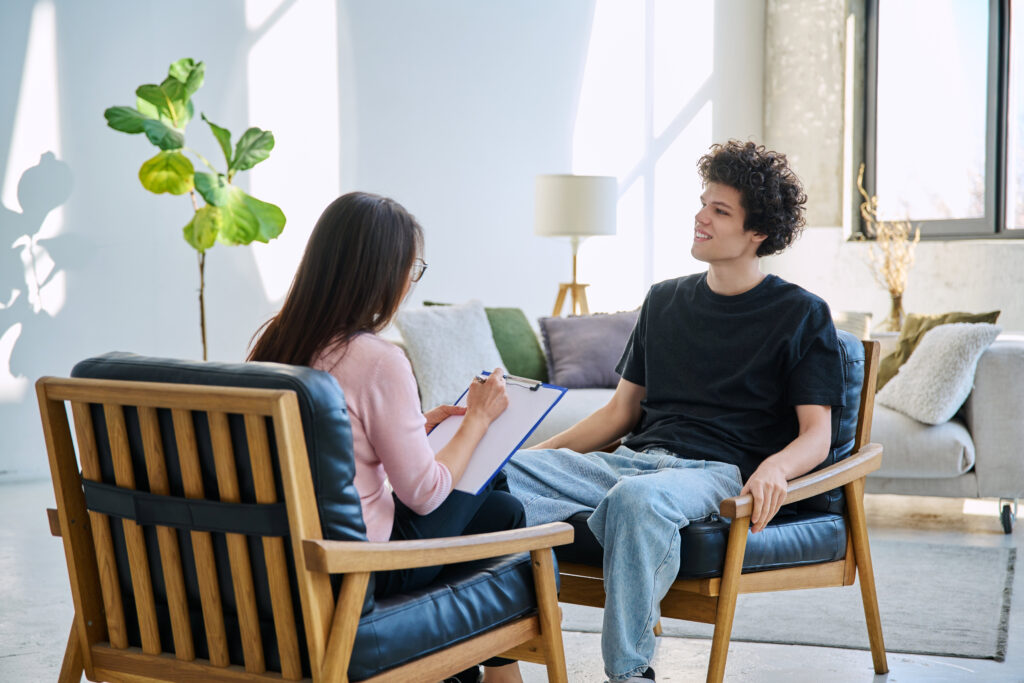 Young man talking to a woman at the Roslindale rehab​ drug center.