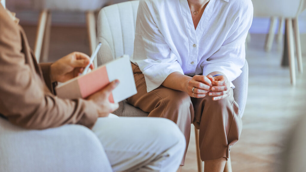 Woman talking to another woman taking notes at the Roslindale rehab​ drug center.