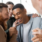 Man being supported by other men in early sobriety.